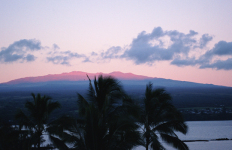 From Hilo City, Mauna Kea is seen reflected in red in the morning sun.