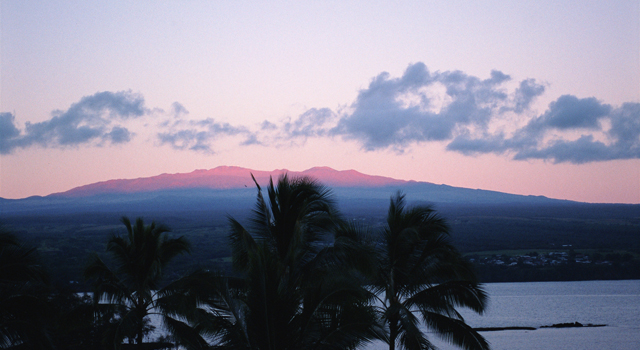 From Hilo City, Mauna Kea is seen reflected in red in the morning sun.