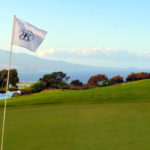 The King Kamehameha Golf Club 18th pin flag Maui coastline background
